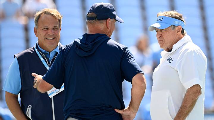 Sep 13, 2025; Chapel Hill, North Carolina, USA; Richmond Spiders head coach Russ Huesman talks to North Carolina Tar Heels general manger Michael Lombardi and head coach Bill Belichick before the game at Kenan Stadium. Mandatory Credit: Bob Donnan-Imagn Images Sep 13, 2025; Chapel Hill, North Carolina, USA; Richmond Spiders head coach Russ Huesman talks to North Carolina Tar Heels general manger Michael Lombardi and head coach Bill Belichick before the game at Kenan Stadium. Mandatory Credit: Bob Donnan-Imagn Images