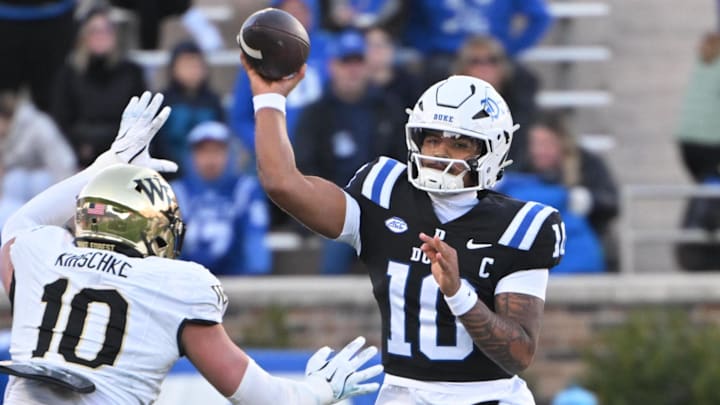Nov 29, 2025; Durham, North Carolina, USA;  Duke Blue Devils quarter back Darian Mensah (10) throws the ball under pressure from Wake Forest Demon Deacons defensive lineman Gabe Kirschke (10) during the first quarter at Wallace Wade Stadium. Mandatory Credit: Zachary Taft-Imagn Images