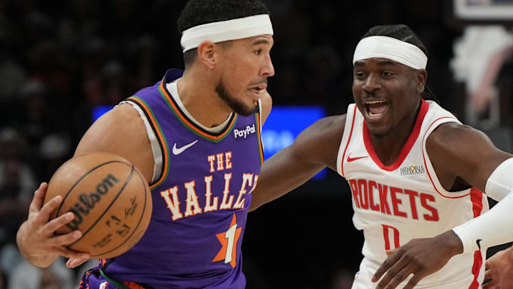 Phoenix Suns guard Devin Booker drives on Houston Rockets guard Aaron Holiday. Phoenix Suns guard Devin Booker drives on Houston Rockets guard Aaron Holiday.