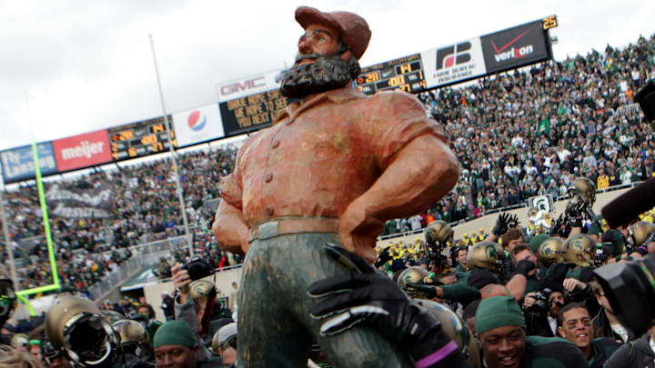 Michigan State players hold up the Paul Bunyan Trophy and run it around the field after their 28-14 win against Michigan at Spartan Stadium on Oct. 15, 2011.