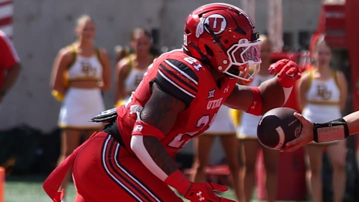 Sep 7, 2024; Salt Lake City, Utah, USA; Utah Utes quarterback Cameron Rising (7) hands the ball off to running back Mike Mitchell (21) against the Baylor Bears during the second quarter at Rice-Eccles Stadium