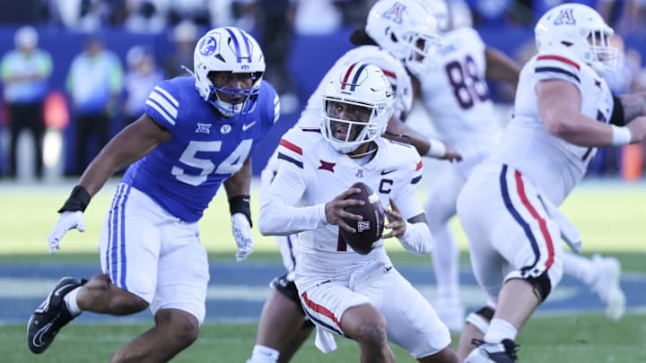Oct 12, 2024; Provo, Utah, USA; Arizona Wildcats quarterback Noah Fifita (11) is rushed by Brigham Young Cougars linebacker Siale Esera (54) during the fourth quarter at LaVell Edwards Stadium. Mandatory Credit: Rob Gray-Imagn Images