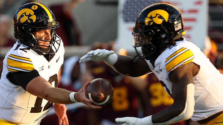 Sep 21, 2024; Minneapolis, Minnesota, USA; Iowa Hawkeyes quarterback Cade McNamara (12) hands the ball off to running back Kaleb Johnson (2) during the first half against the Minnesota Golden Gophers at Huntington Bank Stadium. Mandatory Credit: Matt Krohn-Imagn Images