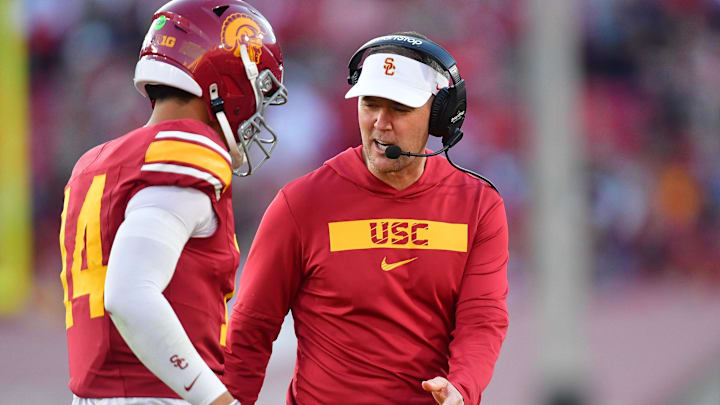 Nov 16, 2024; Los Angeles, California, USA; Southern California Trojans head coach Lincoln Riley greets quarterback Jayden Maiava (14) after scoring a touchdown against the Nebraska Cornhuskers during the second half at the Los Angeles Memorial Coliseum. Mandatory Credit: Gary A. Vasquez-Imagn Images