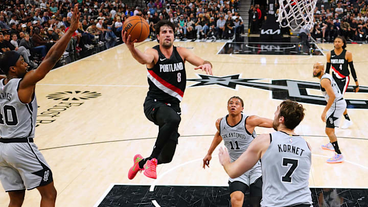Apr 8, 2026; San Antonio, Texas, USA; Portland Trail Blazers forward Deni Avdija (8) drives to the basket between San Antonio Spurs forwards Carter Bryant (11) and Harrison Barnes (40) and center Luke Kornet (7) during the first half at Frost Bank Center.