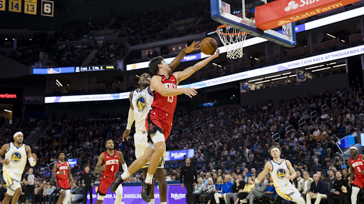 Dec 5, 2024; San Francisco, California, USA;  Houston Rockets guard Reed Sheppard (15) lays up the ball as Golden State Warriors forward Kevon Looney (5) defends during the fourth quarter at Chase Center. Mandatory Credit: John Hefti-Imagn Images