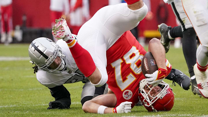 Dec 25, 2023; Kansas City, Missouri, USA; Kansas City Chiefs tight end Travis Kelce (87) is tackled by Las Vegas Raiders safety Tre'von Moehrig (25) during the game at GEHA Field at Arrowhead Stadium. Mandatory Credit: Denny Medley-Imagn Images