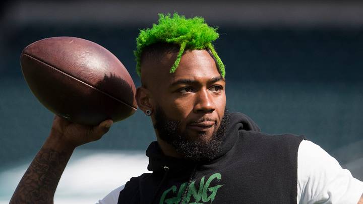 Former Eagles defensive back Jalen Mills throws the ball around with teammates before home game