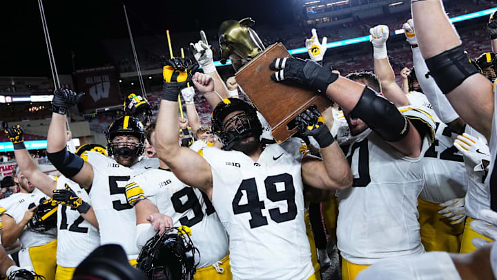 Oct 11, 2025; Madison, Wisconsin, USA; The Iowa Hawkeyes celebrate a win with The Heartland Trophy after the game against the Wisconsin Badgers at Camp Randall Stadium. Mandatory Credit: Ross Harried-Imagn Images Oct 11, 2025; Madison, Wisconsin, USA; The Iowa Hawkeyes celebrate a win with The Heartland Trophy after the game against the Wisconsin Badgers at Camp Randall Stadium. Mandatory Credit: Ross Harried-Imagn Images