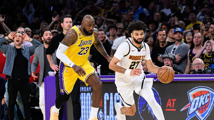 Mar 14, 2026; Los Angeles, California, USA; Denver Nuggets guard Jamal Murray (27) controls the ball while under pressure from Los Angeles Lakers forward LeBron James (23)during the second half at Crypto.com Arena. Mandatory Credit: William Liang-Imagn Images