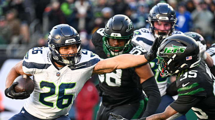 Dec 1, 2024; East Rutherford, New Jersey, USA; Seattle Seahawks running back Zach Charbonnet (26) stiff arms New York Jets safety Jalen Mills (35) during the third quarter at MetLife Stadium.