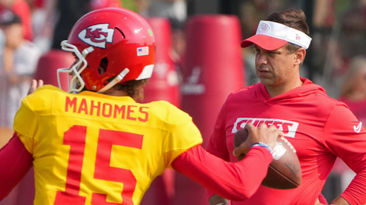 Jul 26, 2024; Kansas City, MO, USA; Kansas City Chiefs quarterback Patrick Mahomes (15) throws a pass as general manager Brett Veach watches in the background during training camp at Missouri Western State University. Mandatory Credit: Denny Medley-Imagn Images