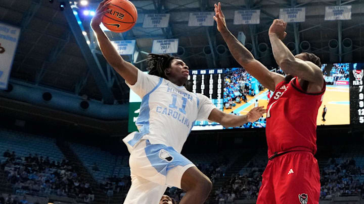Feb 19, 2025; Chapel Hill, North Carolina, USA; North Carolina Tar Heels guard Ian Jackson (11) shoots as North Carolina State Wolfpack forward Brandon Huntley-Hatfield (1) defends in the second half at Dean E. Smith Center. Mandatory Credit: Bob Donnan-Imagn Images