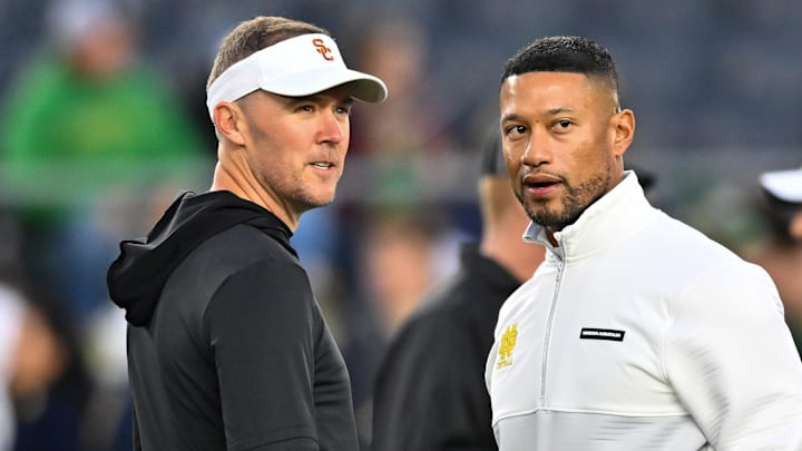 Oct 14, 2023; South Bend, Indiana, USA; USC Trojans head coach Lincoln Riley and Notre Dame Fighting Irish head coach Marcus Freeman chat before the game at Notre Dame Stadium. Mandatory Credit: Matt Cashore-Imagn Images Oct 14, 2023; South Bend, Indiana, USA; USC Trojans head coach Lincoln Riley and Notre Dame Fighting Irish head coach Marcus Freeman chat before the game at Notre Dame Stadium. Mandatory Credit: Matt Cashore-Imagn Images