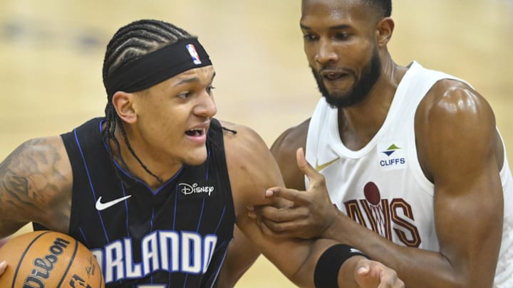 Apr 22, 2024; Cleveland, Ohio, USA; Orlando Magic forward Paolo Banchero (5) drives against Cleveland Cavaliers forward Evan Mobley (4) in the first quarter during game two of the first round of the 2024 NBA playoffs at Rocket Mortgage FieldHouse. Mandatory Credit: David Richard-Imagn Images