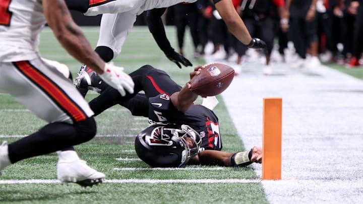 Atlanta Falcons quarterback Michael Penix Jr. reaches for the first down in what would be an 18-play touchdown drive.
