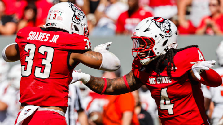Oct 4, 2025; Raleigh, North Carolina, USA; NC State Wolfpack defensive end Tra Thomas (4) and linebacker Jr. Kenny Soares (33) celebrate a tackle during the first half of the game against Campbell Fighting Camels at Carter-Finley Stadium. Mandatory Credit: Jaylynn Nash-Imagn Images