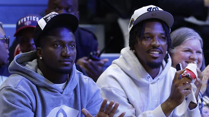 May 16, 2025; Washington, District of Columbia, USA; Washington Commanders wide receiver Deebo Samuel (L) and Commanders quarterback Jayden Daniels (R) wave to the crowd from courts wide during the game between the Washington Mystics and Atlanta Dream at CareFirst Arena. Mandatory Credit: Geoff Burke-Imagn Images