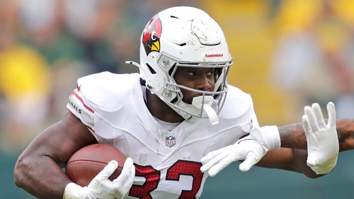 Arizona Cardinals running back Trey Benson (33) runs for a first down against Green Bay Packers cornerback Keisean Nixon (25) in the third quarter during their football game Sunday, October 13, 2024, at Lambeau Field in Green Bay, Wisconsin. Arizona Cardinals running back Trey Benson (33) runs for a first down against Green Bay Packers cornerback Keisean Nixon (25) in the third quarter during their football game Sunday, October 13, 2024, at Lambeau Field in Green Bay, Wisconsin.