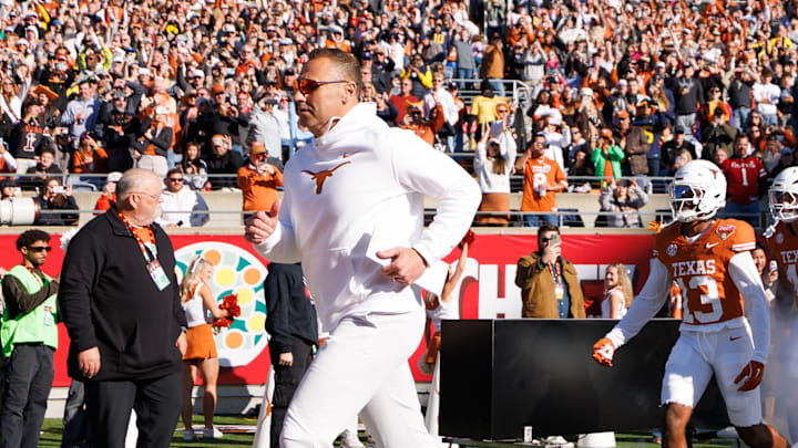 Texas Longhorns head coach Steve Sarkisian, Texas Longhorns wide receiver Parker Livingstone (13) and offensive lineman Brandon Baker (73) run onto the field before a game against the Michigan Wolverines.