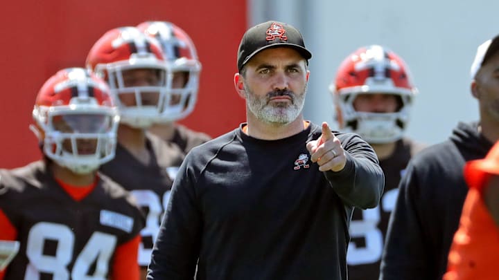 Cleveland Browns coach Kevin Stefanski watches quarterback Shedeur Sanders (12) participate in drills during day two of NFL rookie minicamp at the Cleveland Browns training facility May 10, 2025, in Berea, Ohio.