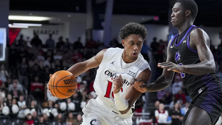 Nov 3, 2025; Cincinnati, Ohio, USA;  Cincinnati Bearcats forward Baba Miller (18) drives to the basket against Western Carolina Catamounts forward Samuel Dada (12) in the first half at Fifth Third Arena. Mandatory Credit: Aaron Doster-Imagn Images