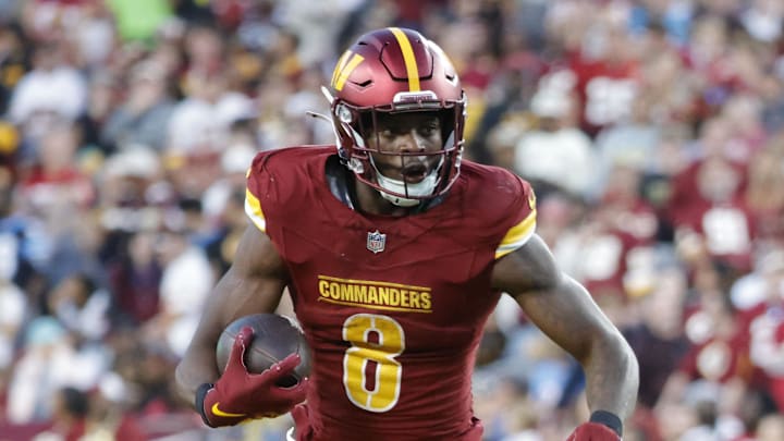 Oct 20, 2024; Landover, Maryland, USA; Washington Commanders running back Brian Robinson Jr. (8) carries the ball as Carolina Panthers cornerback Michael Jackson (2) and Panthers linebacker DJ Johnson (52) defends during the second half at Northwest Stadium. Mandatory Credit: Amber Searls-Imagn Images