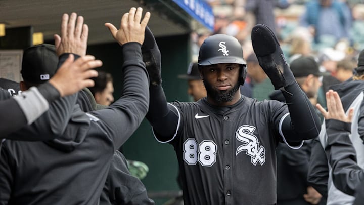 Chicago White Sox outfielder Luis Robert Jr. (88) high-fives teammates in the dugout after scoring against the Detroit Tigers at Comerica Park. 