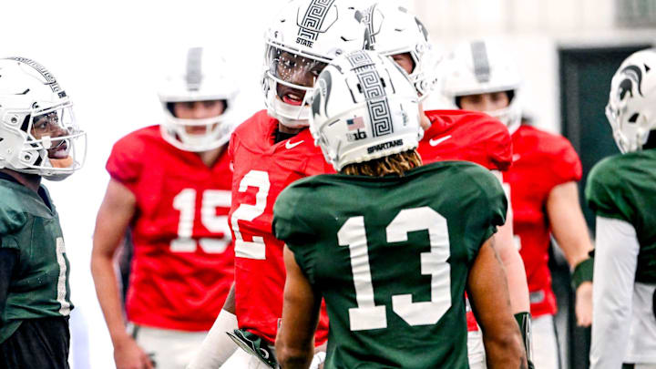 Michigan State quarterback Aidan Chiles, center, talks with receivers Chrishon McCray, right, and Nick Marsh during football practice on Tuesday, April 8, 2025, in East Lansing. Michigan State quarterback Aidan Chiles, center, talks with receivers Chrishon McCray, right, and Nick Marsh during football practice on Tuesday, April 8, 2025, in East Lansing.