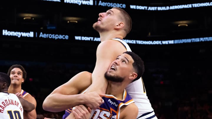 Phoenix Suns guard Devin Booker battles for position against Denver Nuggets center Nikola Jokic (15) in the second half at Mortgage Matchup Center. Phoenix Suns guard Devin Booker battles for position against Denver Nuggets center Nikola Jokic (15) in the second half at Mortgage Matchup Center.
