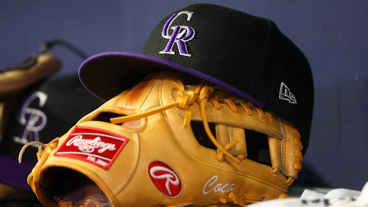 Jun 15, 2023; Atlanta, Georgia, USA; A detailed view of a Colorado Rockies hat and glove on the bench against the Atlanta Braves in the ninth inning at Truist Park. 