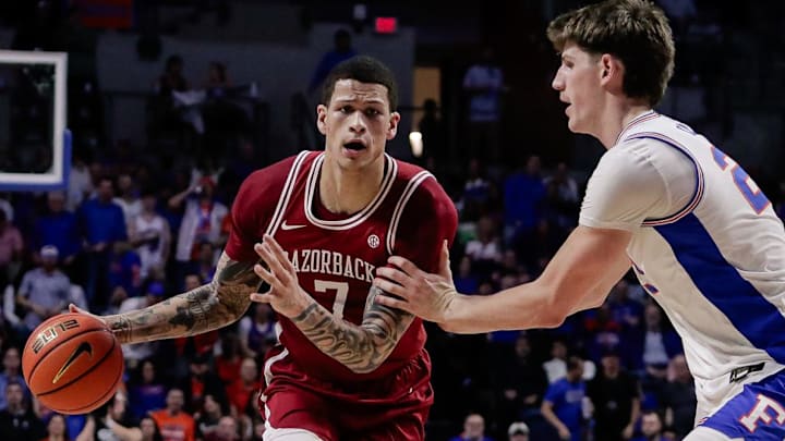 Arkansas Razorbacks forward Trevon Brazile (7) handles the ball against Florida Gators forward/center Alex Condon (21) during the first half at Exactech Arena at the Stephen C. O'Connell Center in Gainesville, Fla.