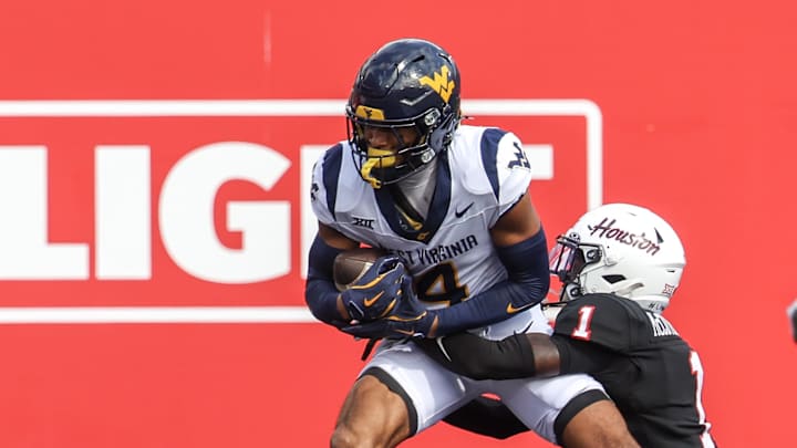 Nov 1, 2025; Houston, Texas, USA; West Virginia Mountaineers wide receiver Cam Vaughn (4) catches a touchdown pass against Houston Cougars defensive back Latrell McCutchin Sr. (1) in the first half at TDECU Stadium. Mandatory Credit: Thomas Shea-Imagn Images