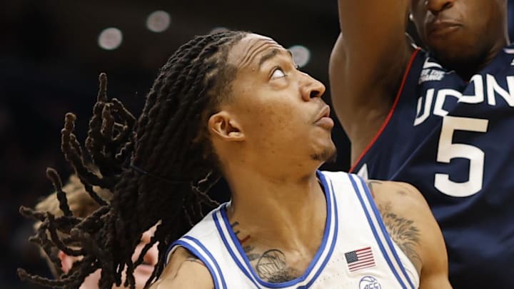 Mar 29, 2026; Washington, DC, USA; UConn Huskies forward Tarris Reed Jr. (5) rebounds over Duke Blue Devils forward Maliq Brown (6) during an Elite Eight game of the East Regional of the men's 2026 NCAA Tournament at Capital One Arena. Mandatory Credit: Geoff Burke-Imagn Images