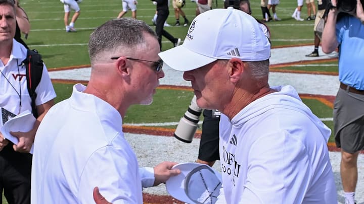 Sep 20, 2025; Blacksburg, Virginia, USA;  Virginia Tech Hokies head coach Phillip Montgomery and Wofford Terriers head coach Shawn Watson shake hands after the game at Lane Stadium. Mandatory Credit: Brian Bishop-Imagn Images