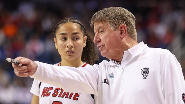 Mar 9, 2025; Greensboro, NC, USA;  NC State Wolfpack head coach Wes Moore talks with NC State Wolfpack guard Devyn Quigley (0) during the fourth quarter against Duke Blue Devils at First Horizon Coliseum. Mandatory Credit: Cory Knowlton-Imagn Images