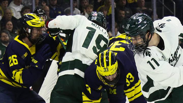 A pileup of Michigan State Spartans and Michigan Wolverines at the net  in the 2024 Big Ten championship at Munn Ice Arena in East Lansing.