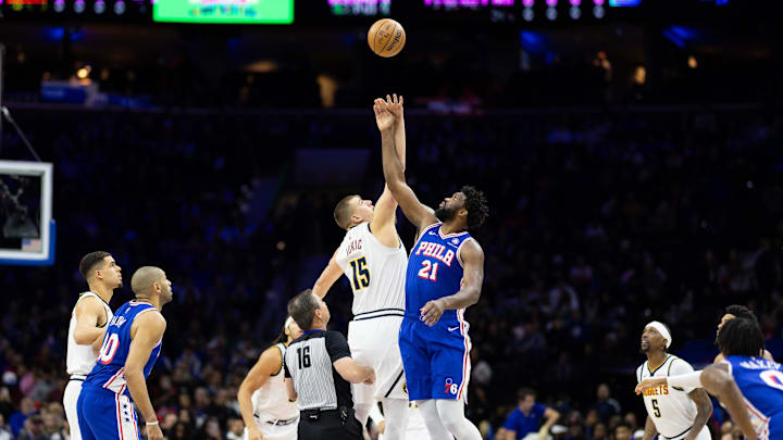 Philadelphia 76ers center Joel Embiid (21) and Denver Nuggets center Nikola Jokic (15) tip off to start the game at Wells Fargo Center. Mandatory Credit: Bill Streicher-Imagn Images