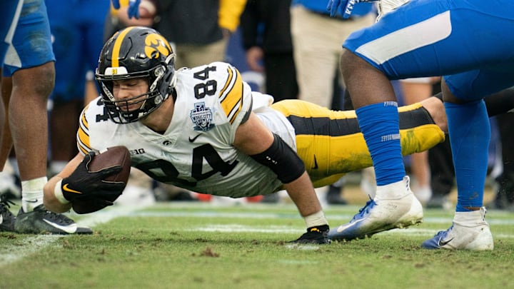 Iowa tight end Sam LaPorta (84) dives for extra yards past Kentucky defenders during the third