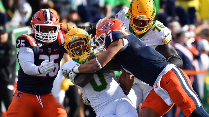 Illinois defensive back Matthew Bailey tackles Oregon running back Jordon Davison. The Ducks are out of College Football Playoff contention. Illinois defensive back Matthew Bailey tackles Oregon running back Jordon Davison. The Ducks are out of College Football Playoff contention.