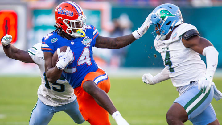 Florida Gators running back Ja'Kobi Jackson (24) pushes off of Tulane Green Wave linebacker Chris Rodgers (4) during the first half at Raymond James Stadium in Tampa, FL on Friday, December 20, 2024 in the 2024 Union Home Mortgage Gasparilla Bowl