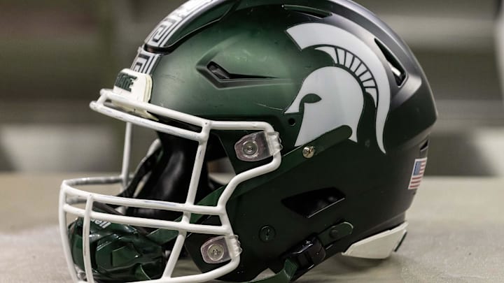 Nov 24, 2023; Detroit, Michigan, USA; A Michigan State Spartans helmet sits on a bench during the second half game against the Penn State Nittany Lions at Ford Field. Mandatory Credit: David Reginek-Imagn Images Nov 24, 2023; Detroit, Michigan, USA; A Michigan State Spartans helmet sits on a bench during the second half game against the Penn State Nittany Lions at Ford Field. Mandatory Credit: David Reginek-Imagn Images