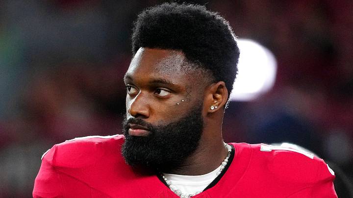 Cardinals Trey Benson (33) and Josh Sweat (10) warm up on the sidelines during a preseason game against the Raiders at State Farm Stadium in Glendale on Aug. 23, 2025.