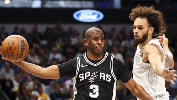 Nov 16, 2024; Dallas, Texas, USA;  San Antonio Spurs guard Chris Paul (3) passes around Dallas Mavericks center Dereck Lively II (2) during the first half at American Airlines Center. Mandatory Credit: Kevin Jairaj-Imagn Images