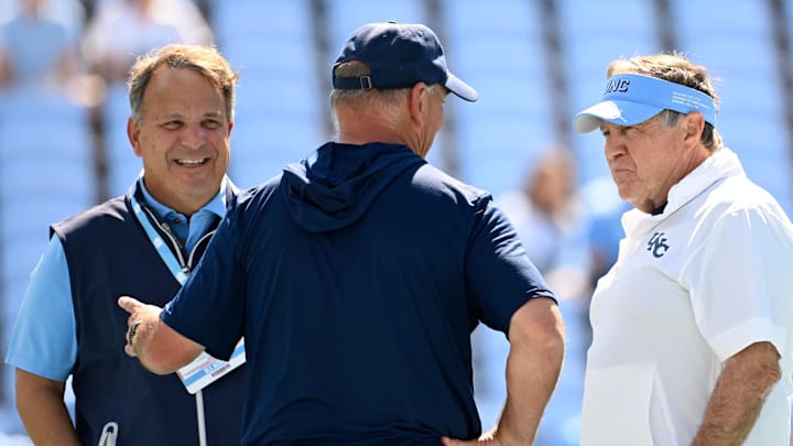 Sep 13, 2025; Chapel Hill, North Carolina, USA; Richmond Spiders head coach Russ Huesman talks to North Carolina Tar Heels general manager Michael Lombardi and head coach Bill Belichick before the game at Kenan Stadium. Mandatory Credit: Bob Donnan-Imagn Images Sep 13, 2025; Chapel Hill, North Carolina, USA; Richmond Spiders head coach Russ Huesman talks to North Carolina Tar Heels general manager Michael Lombardi and head coach Bill Belichick before the game at Kenan Stadium. Mandatory Credit: Bob Donnan-Imagn Images