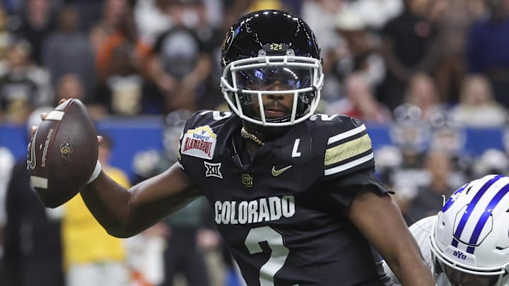 Dec 28, 2024; San Antonio, TX, USA; Colorado Buffaloes quarterback Shedeur Sanders (2) attempts to avoid a tackle by Brigham Young Cougars safety Raider Damuni (3) during the second quarter at Alamodome. Mandatory Credit: Troy Taormina-Imagn Images