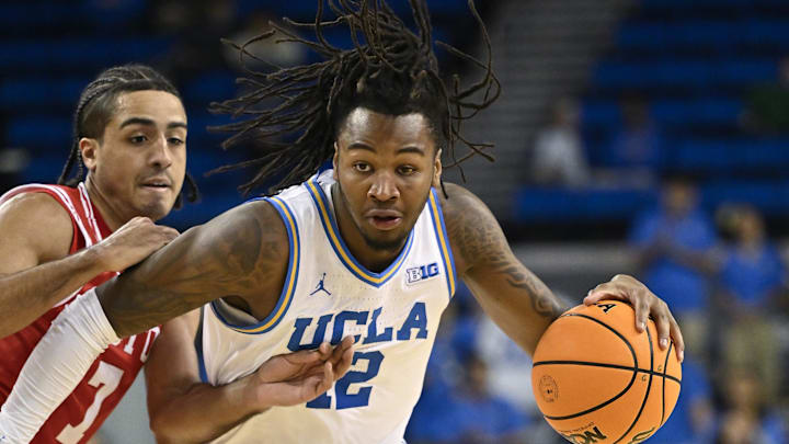 Nov 11, 2024; Los Angeles, California, USA; UCLA Bruins guard Sebastian Mack (12) drives around Boston University Terriers guard Azmar Abdullah (7) during the second half at Pauley Pavilion presented by Wescom. Mandatory Credit: Robert Hanashiro-Imagn Images


