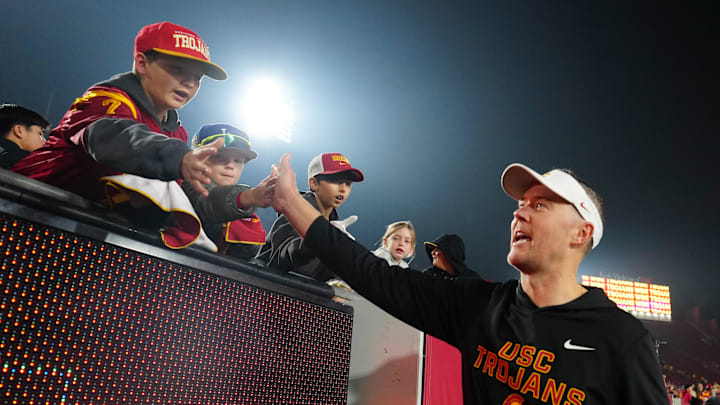 Nov 29, 2025; Los Angeles, California, USA; Southern California Trojans head coach Lincoln Riley celebrates with fans after the game against the UCLA Bruins at United Airlines Field at Los Angeles Memorial Coliseum. Mandatory Credit: Kirby Lee-Imagn Images Nov 29, 2025; Los Angeles, California, USA; Southern California Trojans head coach Lincoln Riley celebrates with fans after the game against the UCLA Bruins at United Airlines Field at Los Angeles Memorial Coliseum. Mandatory Credit: Kirby Lee-Imagn Images