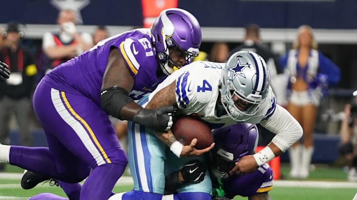 Dec 14, 2025; Arlington, Texas, USA; Dallas Cowboys quarterback Dak Prescott (4) is tackled by Minnesota Vikings defensive tackle Jalen Redmond (61) during the first half at AT&T Stadium. Dec 14, 2025; Arlington, Texas, USA; Dallas Cowboys quarterback Dak Prescott (4) is tackled by Minnesota Vikings defensive tackle Jalen Redmond (61) during the first half at AT&T Stadium.