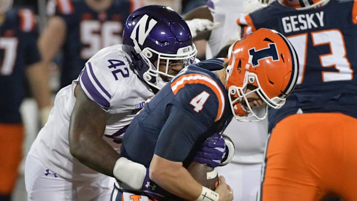 Nov 25, 2023; Champaign, Illinois, USA; Northwestern Wildcats defensive lineman Anto Saka (42) takes down Illinois Fighting Illini quarterback John Paddock (4) during the second half at Memorial Stadium. Mandatory Credit: Ron Johnson-Imagn Images